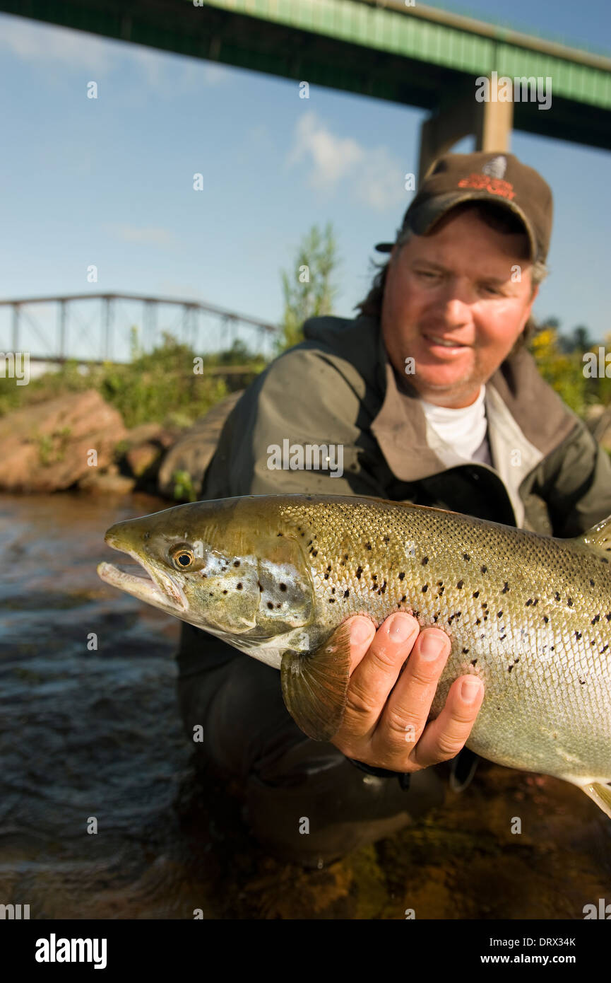 Angler holding an Atlantic salmon caught in the rapids on St. Mary's