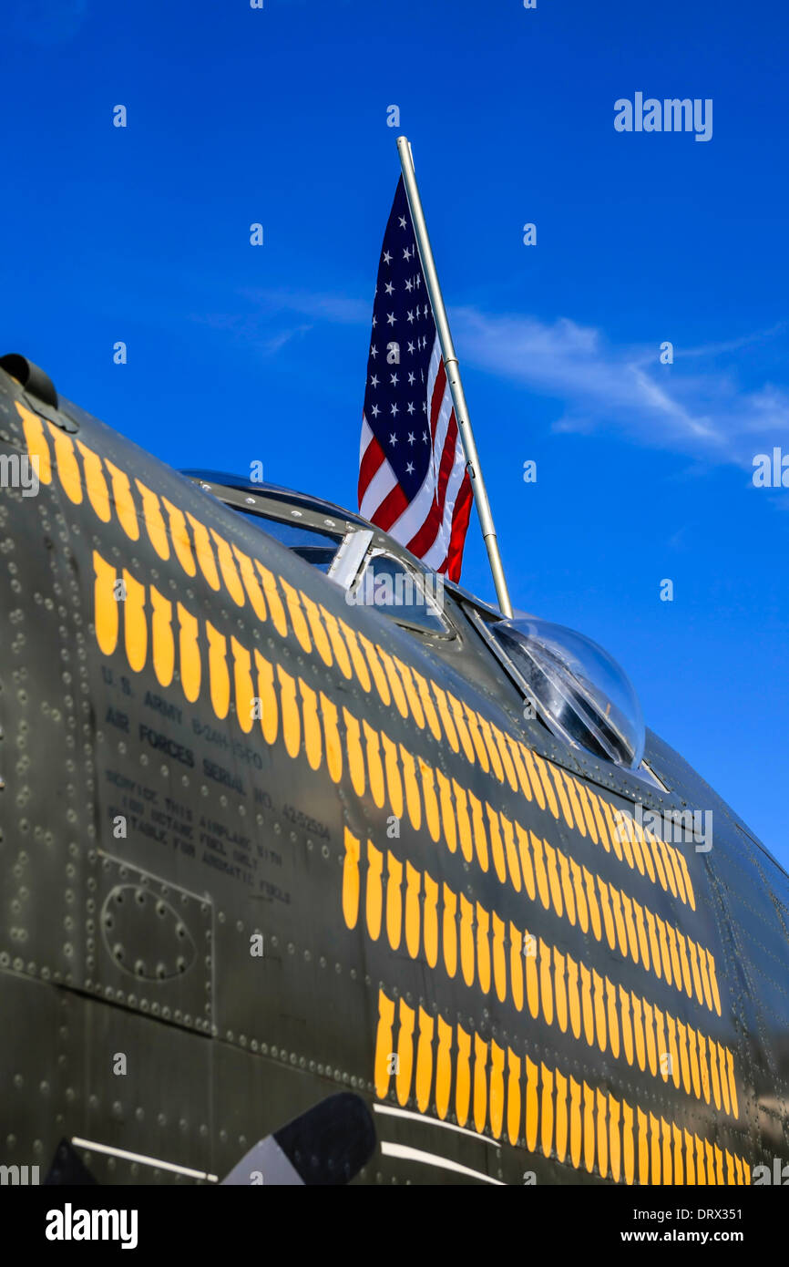 An American flag flies over a WW2 B24 Liberator bomber plane Stock Photo