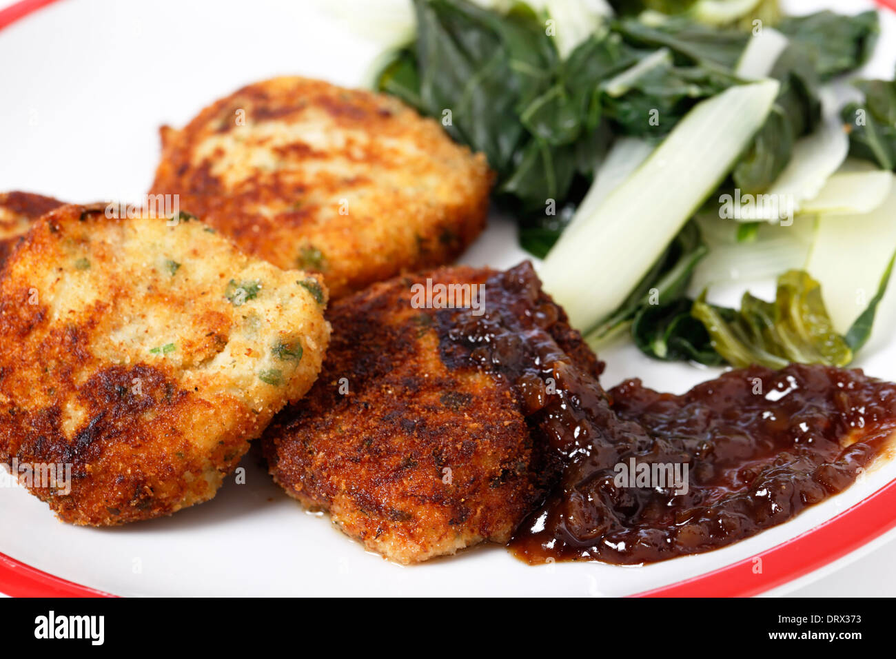 Homemade fishcakes and onion marmalade serves with boiled greens Stock Photo