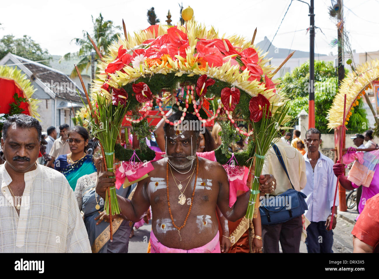 A devotee of Lord Muruga carrying a decorative cavadee and cheeks pierced with a silver spear during the Thaipoosam Cavadee. Stock Photo