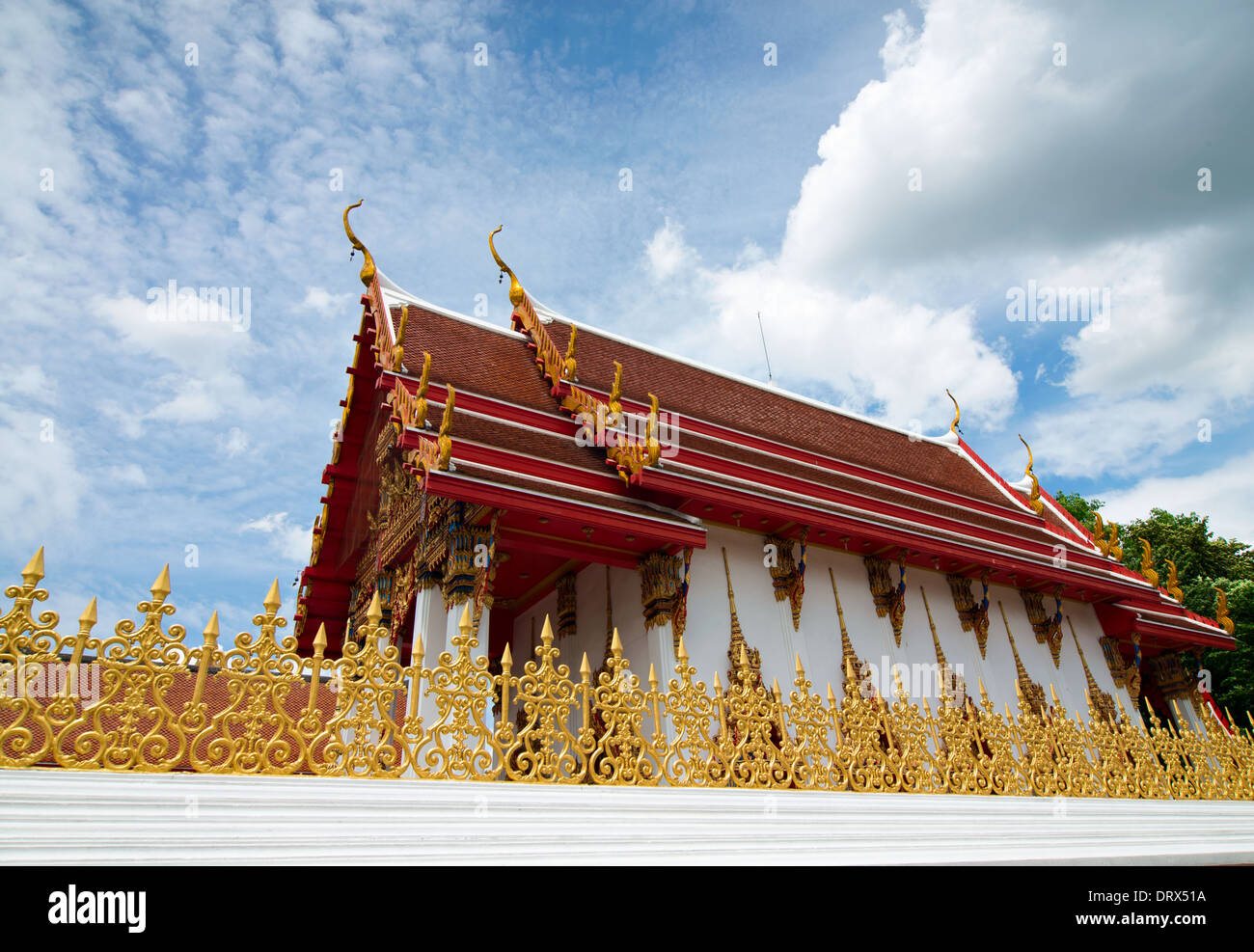 Thai temple building and gold fence, taken against blue sky in Minburi,Thailand Stock Photo