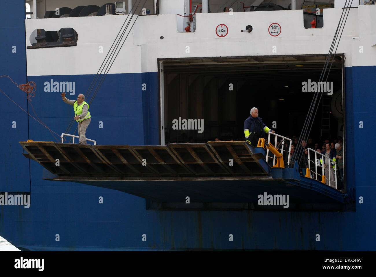 Ship crew guiding heavy duty mooring rope during docking procedure