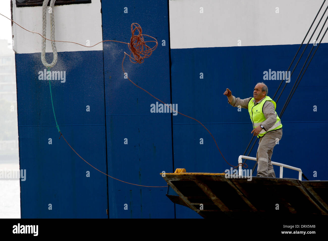 Ship crew guiding heavy duty mooring rope during docking procedure ...