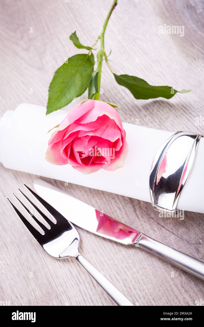 Romantic formal elegant table setting with a single pink rose and ...
