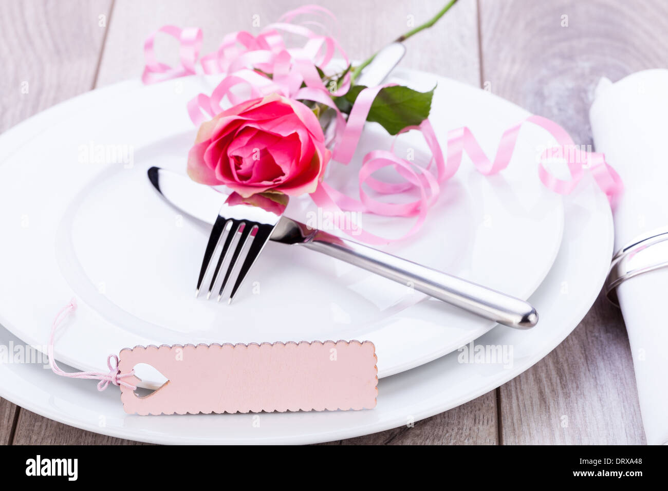 Valentines table setting with an ornamental blank pink gift tag and ...