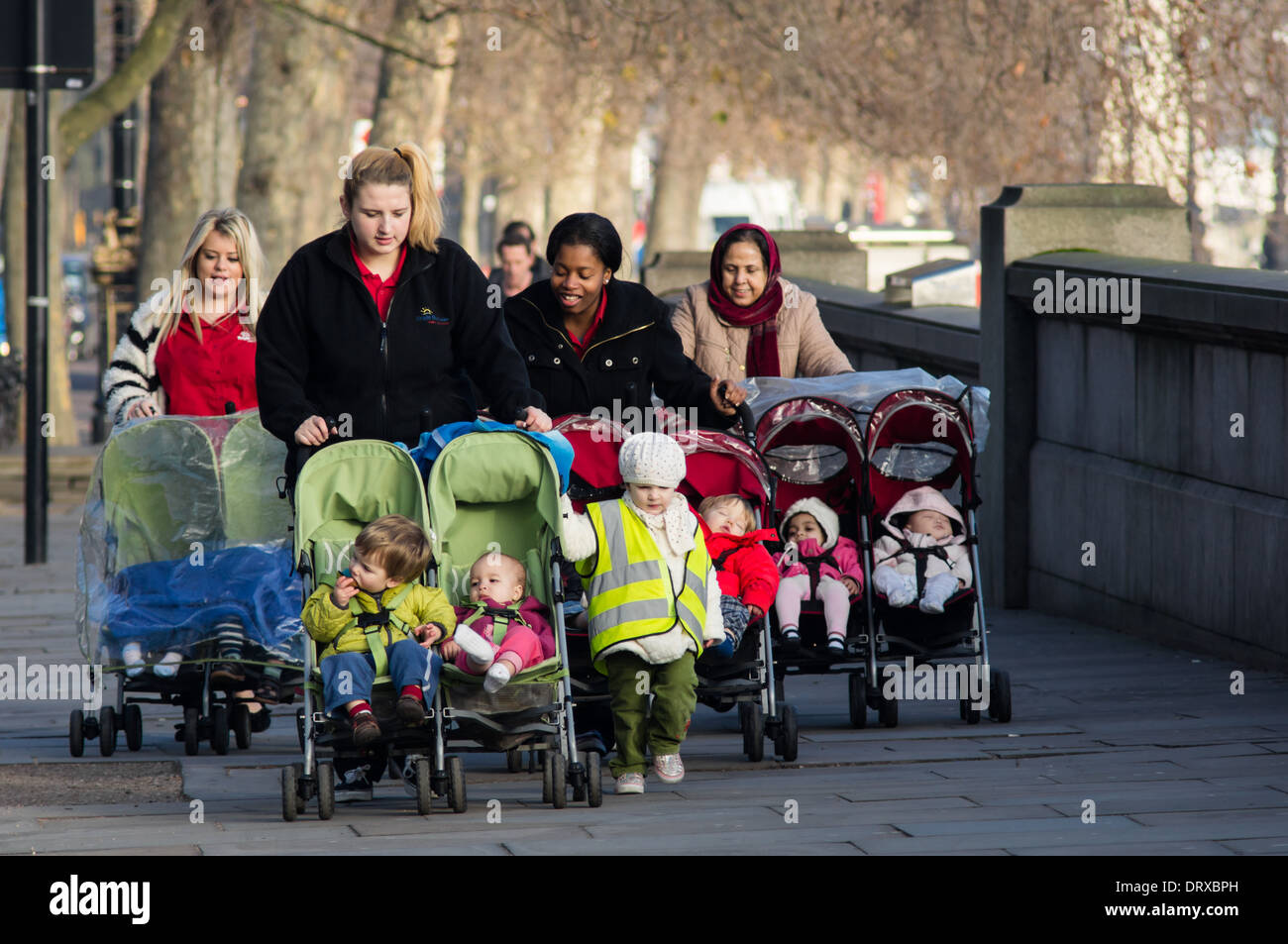 Young mothers walk along Thames bank on a weekday morning, London England United Kingdom UK Stock Photo