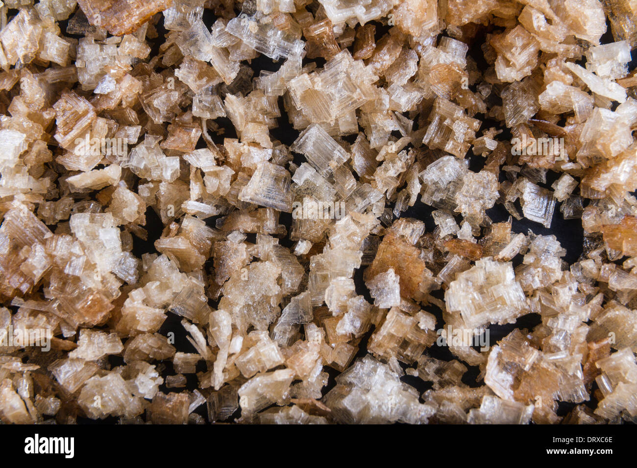 Smoked sea salt flakes, scattered to make background or texture. Macro