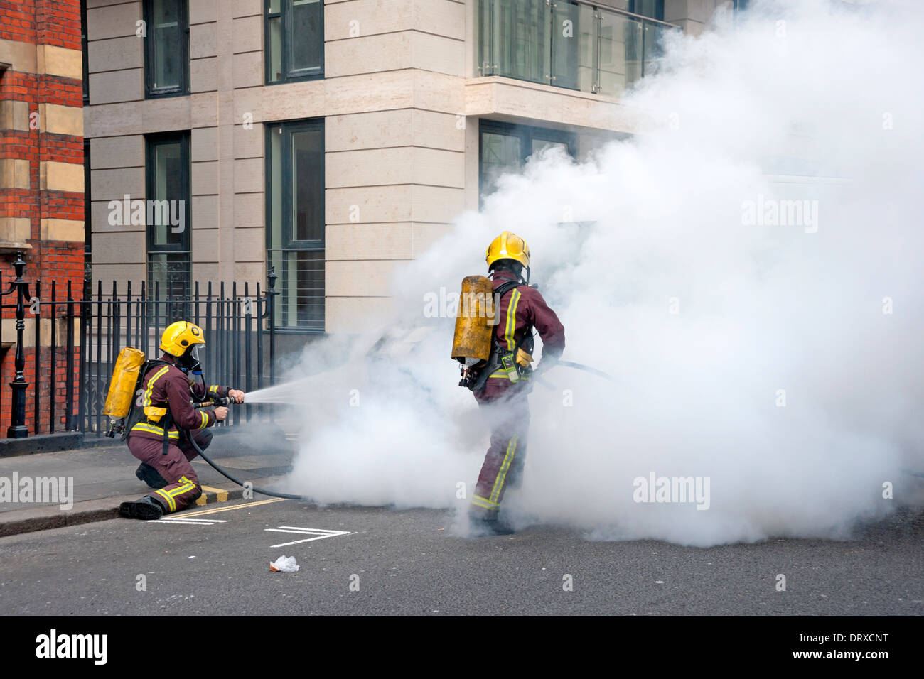 Firemen putting out a fire on a Van in a London Street Stock Photo