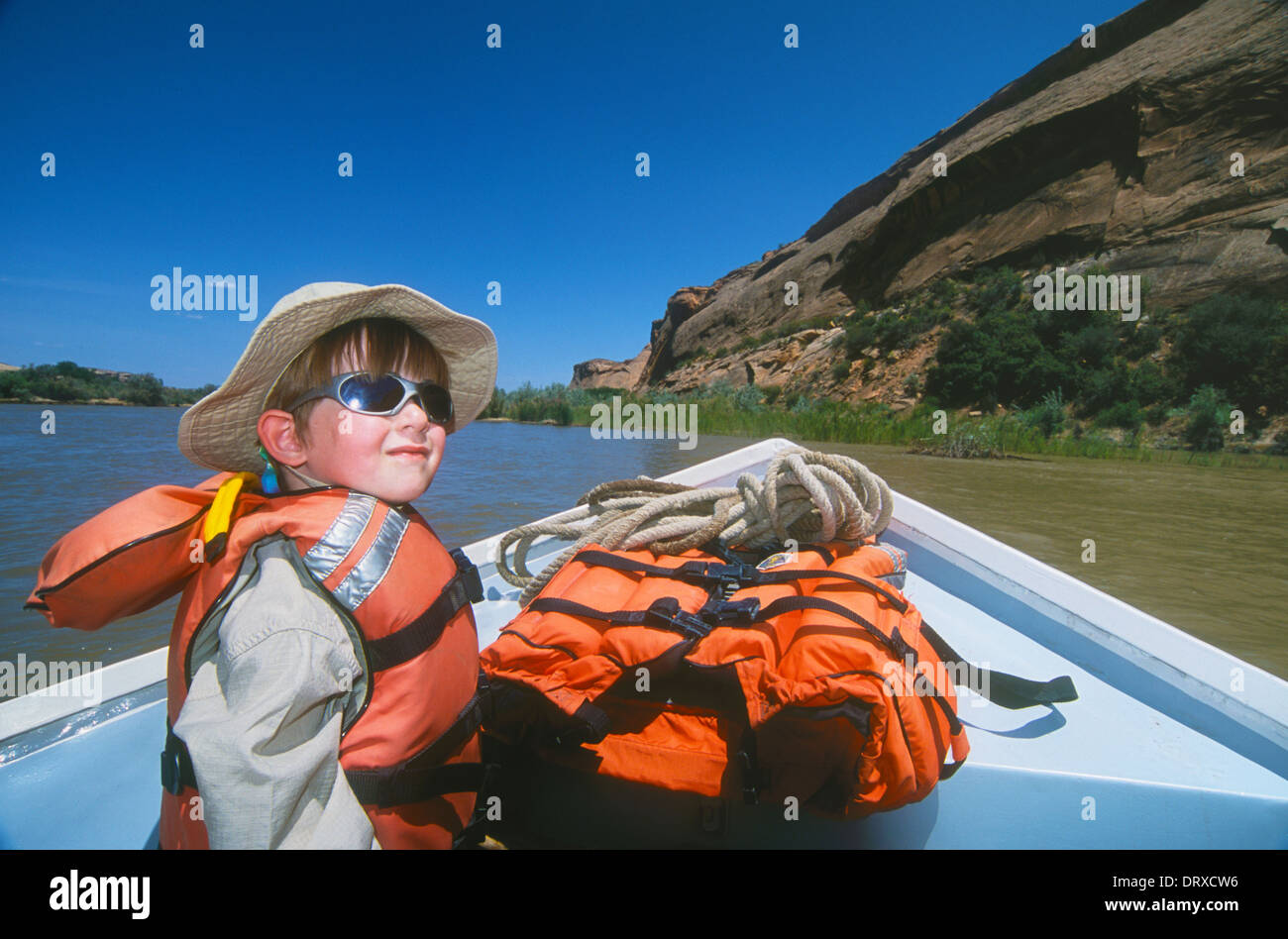 5-year old boy riding in dory on O.A.R.S. outfitters trip on the San Juan River in Utah. Stock Photo