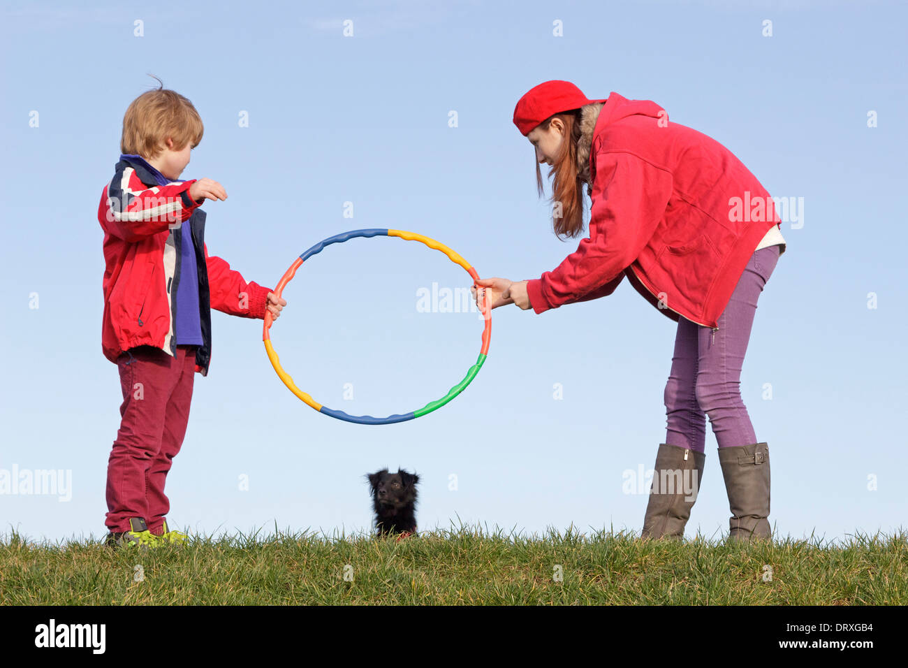 young boy and girl making their dog jump through a hoop Stock Photo Alamy
