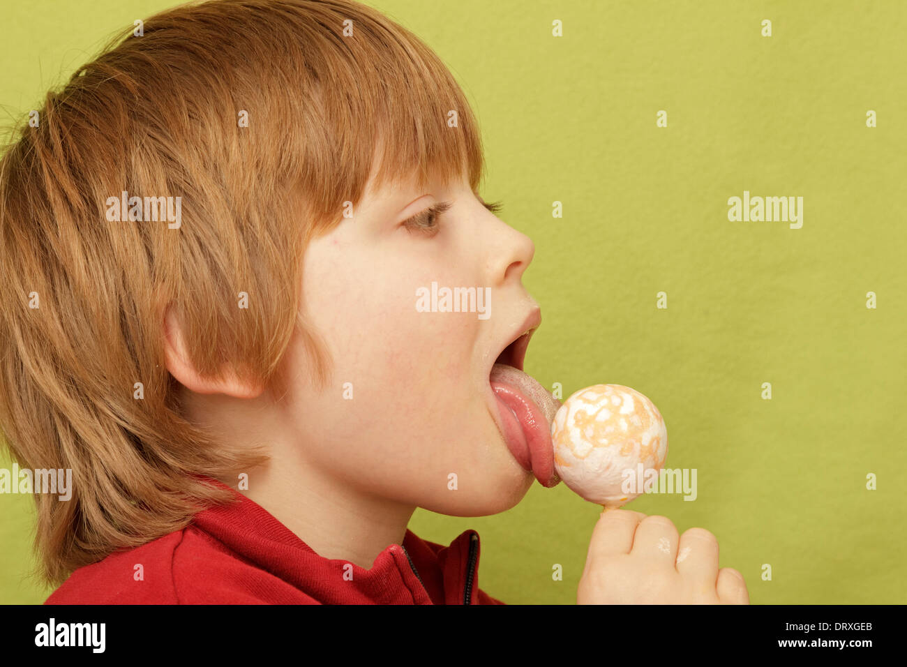portrait of a happy young boy licking a lolly Stock Photo