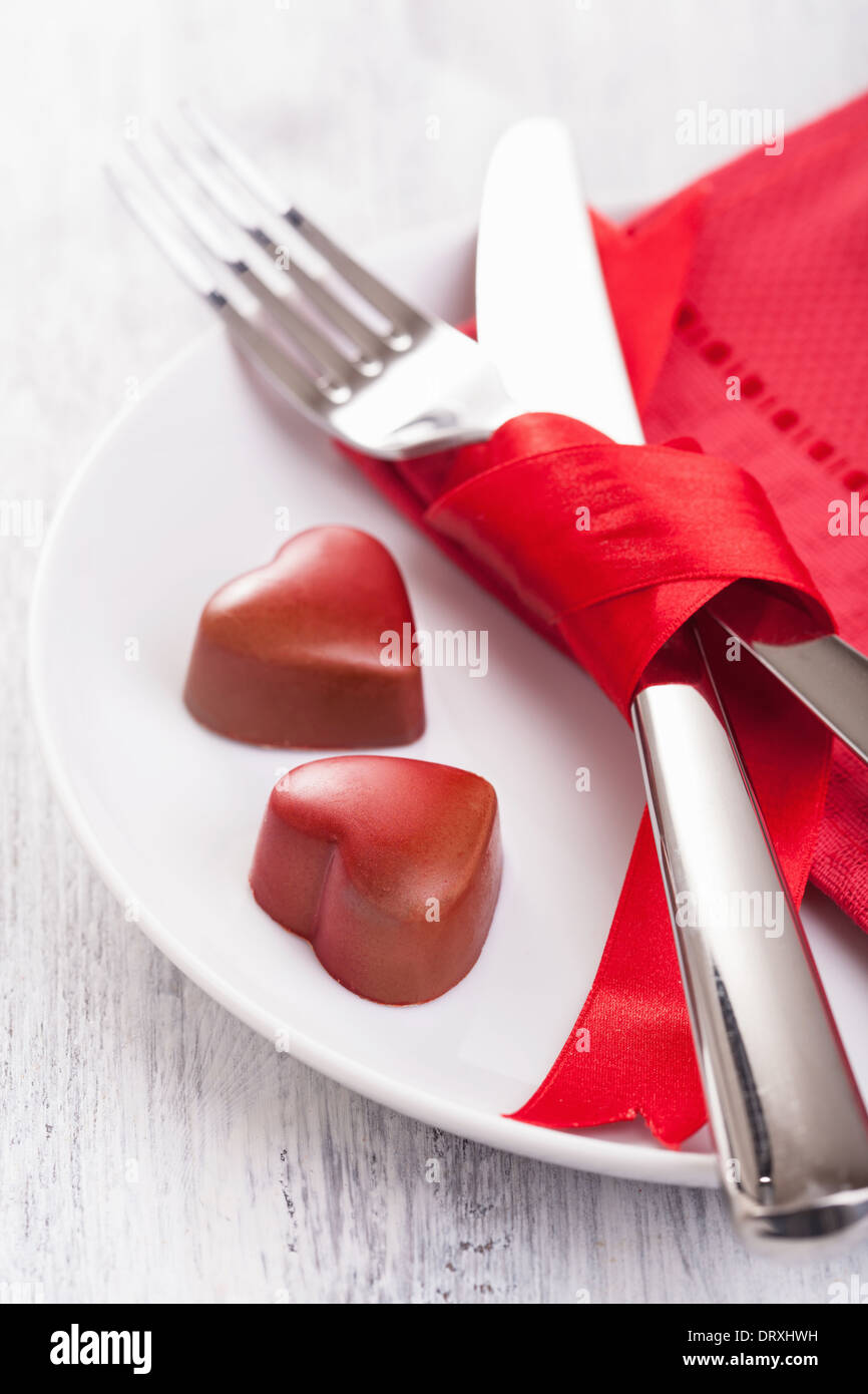 chocolate hearts and silverware on plate for Valentines Stock Photo