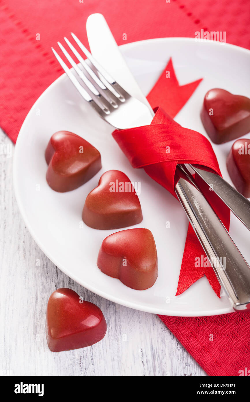 chocolate hearts and silverware on plate for Valentines Stock Photo