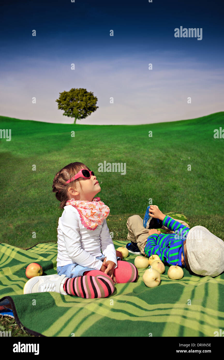 little twins making picnic in the backyard Stock Photo