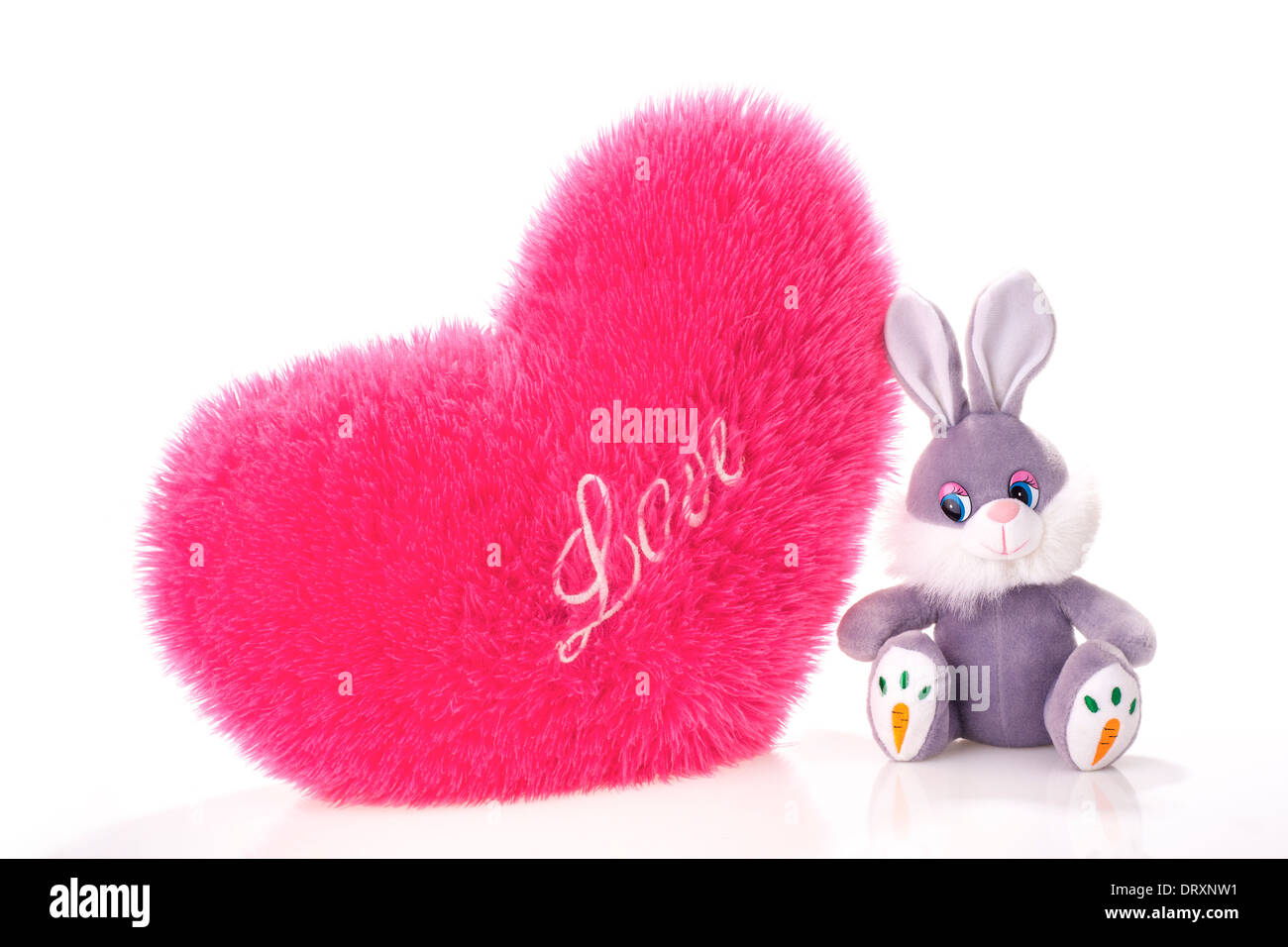 Toy hare and heart-shaped pillow isolated on white Stock Photo