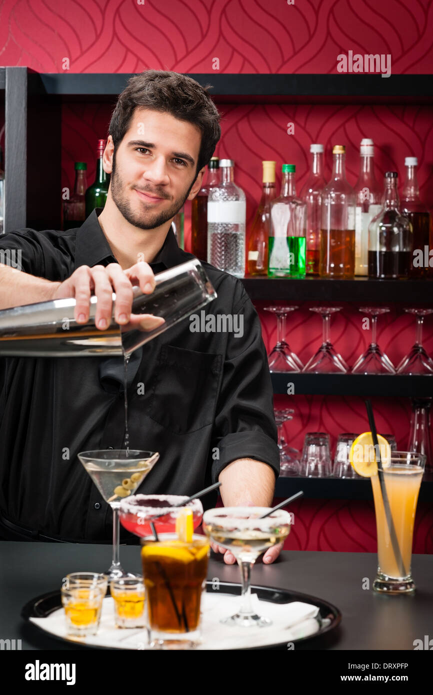 Young bartender make cocktail shaking drinks Stock Photo