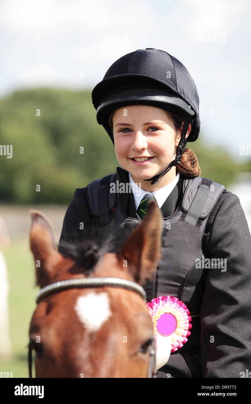 A teenager happy to have won a rosette horse riding Stock Photo