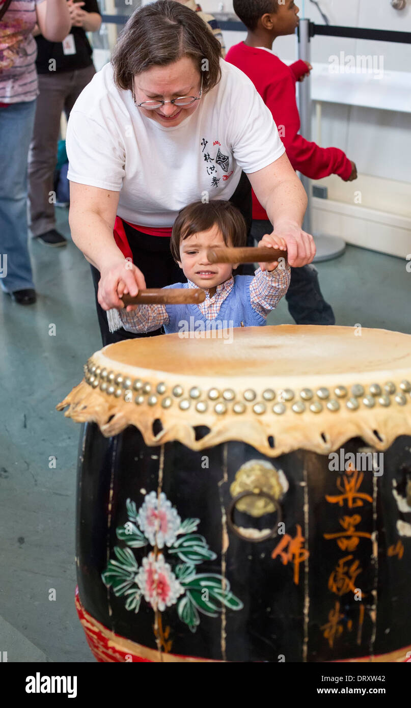 Children get a chance to bang the drums after the Asian Martial Arts Studio performed Lion Dance for the Chinese New Year Stock Photo