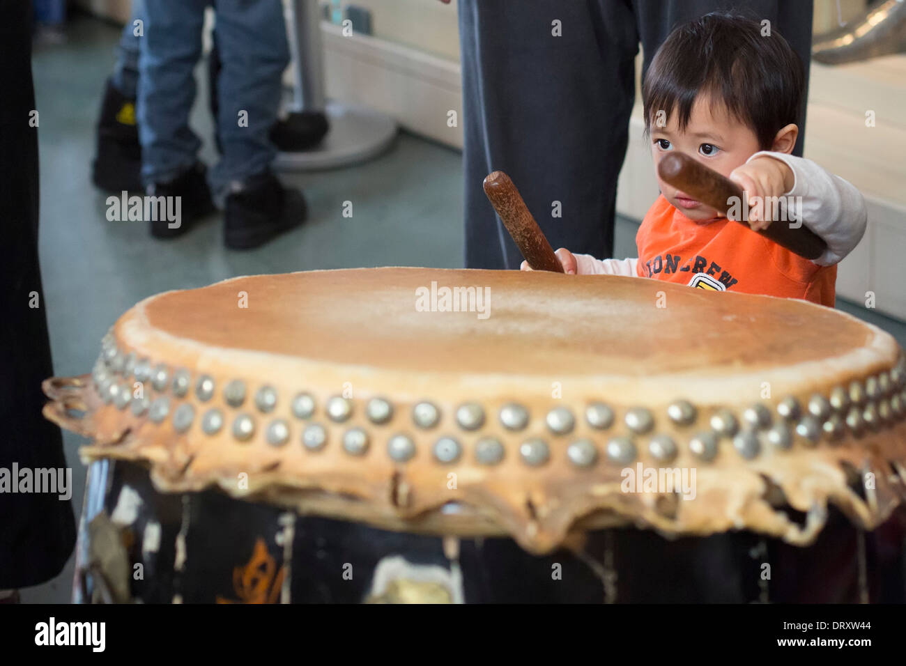 Children get a chance to bang the drums after the Asian Martial Arts Studio performed Lion Dance for the Chinese New Year Stock Photo