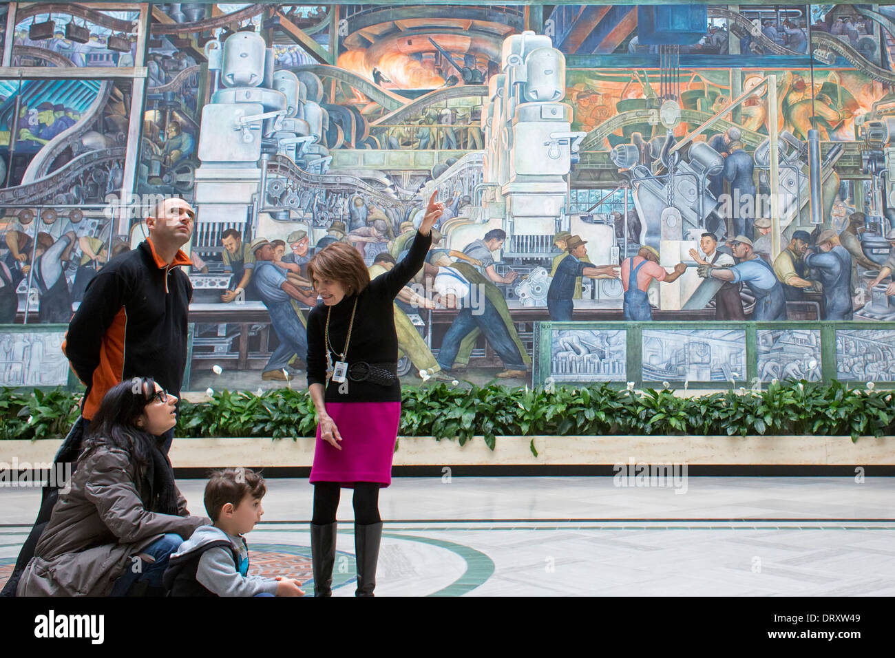 Detroit, Michigan - A docent tells visitors about Diego Rivera's 'Detroit Industry' murals at the Detroit Institute of Arts. Stock Photo