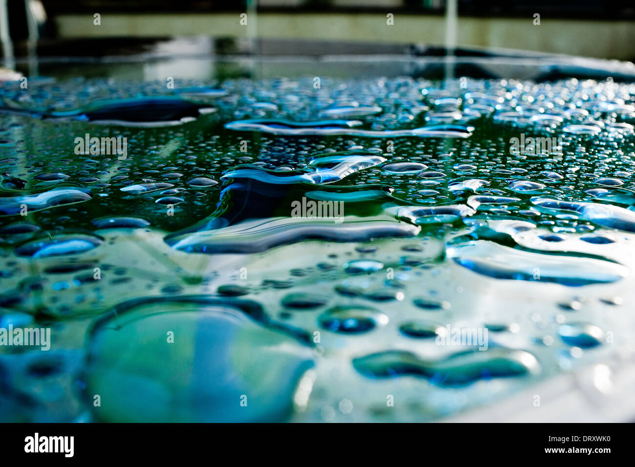 Rain lies on the surface of a glass table after storm Stock Photo