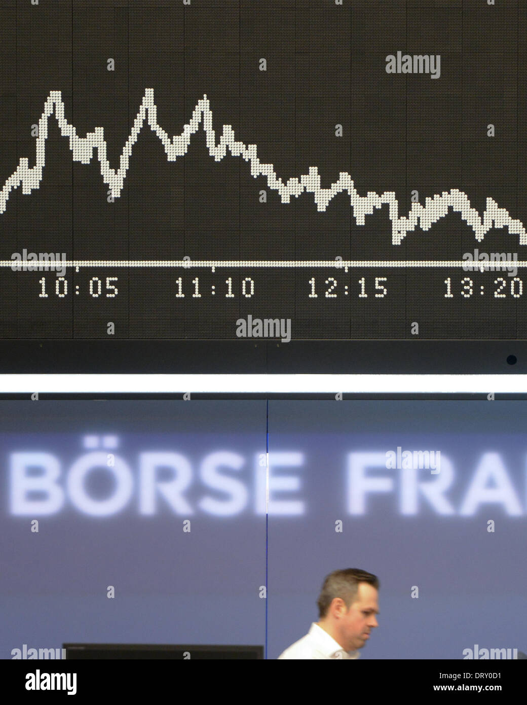 Frankfurt Main, Germany. 04th Feb, 2014. A floor trader walks past a display board with the Dax index at the stock market in Frankfurt Main, Germany, 04 February 2014. Germany's Dax index dropped after a sharp fall in prices in Asia. Photo: Arne Dedert/dpa/Alamy Live News Stock Photo