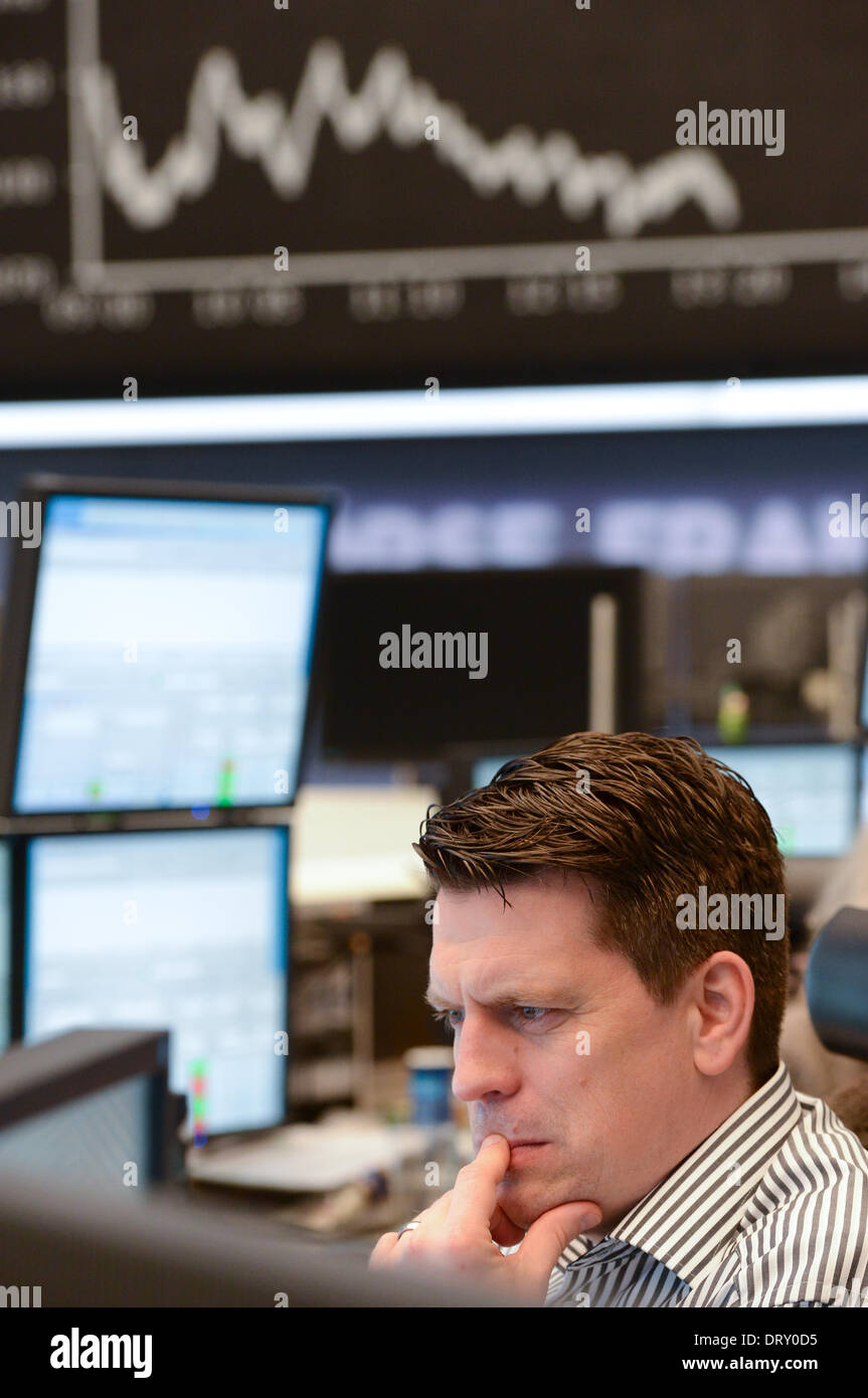 Frankfurt Main, Germany. 04th Feb, 2014. A floor trader looks at his monitors at the stock market in Frankfurt Main, Germany, 04 February 2014. Germany's Dax index dropped after a sharp fall in prices in Asia. Photo: Arne Dedert/dpa/Alamy Live News Stock Photo