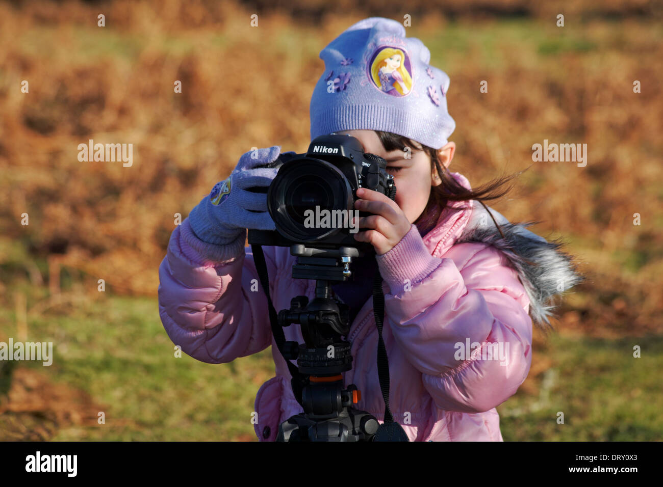 smile - young photographer, young girl taking a photo with Nikon D800 camera on Acratech tripod Stock Photo