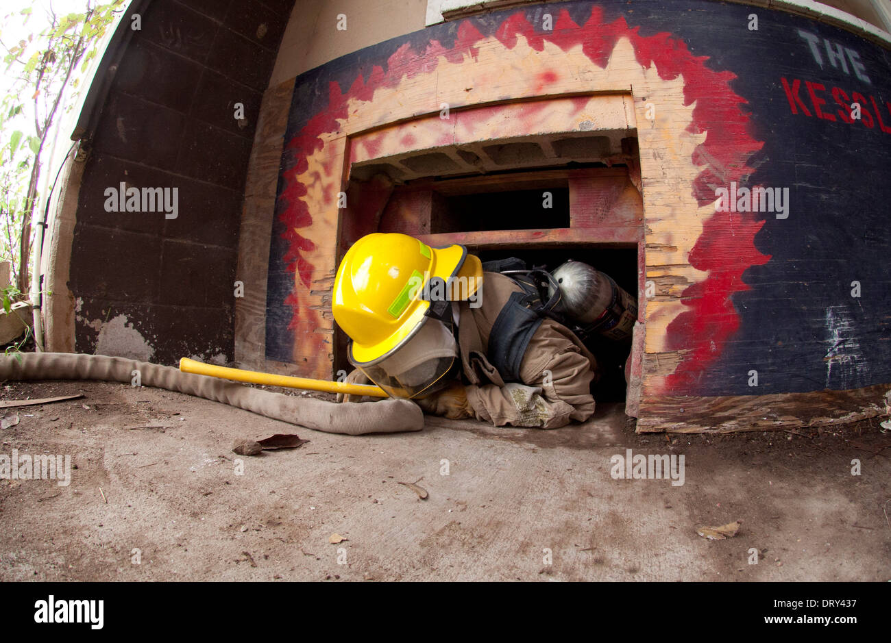 High school fire academy student exits smoke-filled house  to complete search-and-rescue training exercise Stock Photo