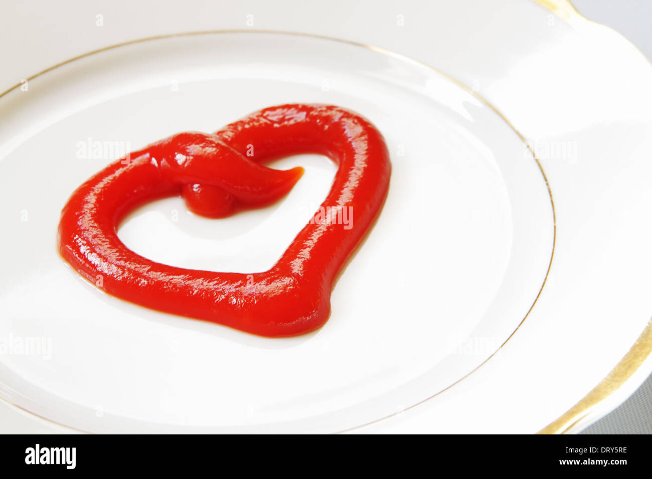 Declaration of love. Ketchup in the form of heart on a white plate. Stock Photo