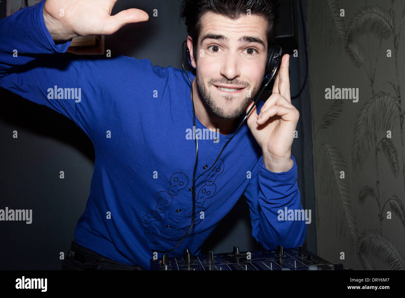 DJ using headphones and audio mixer, portrait Stock Photo Alamy