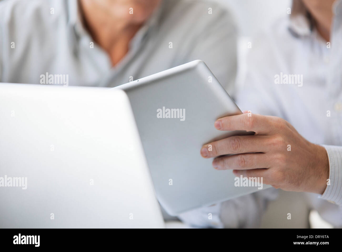 Men using digital tablet and laptop computer, cropped Stock Photo