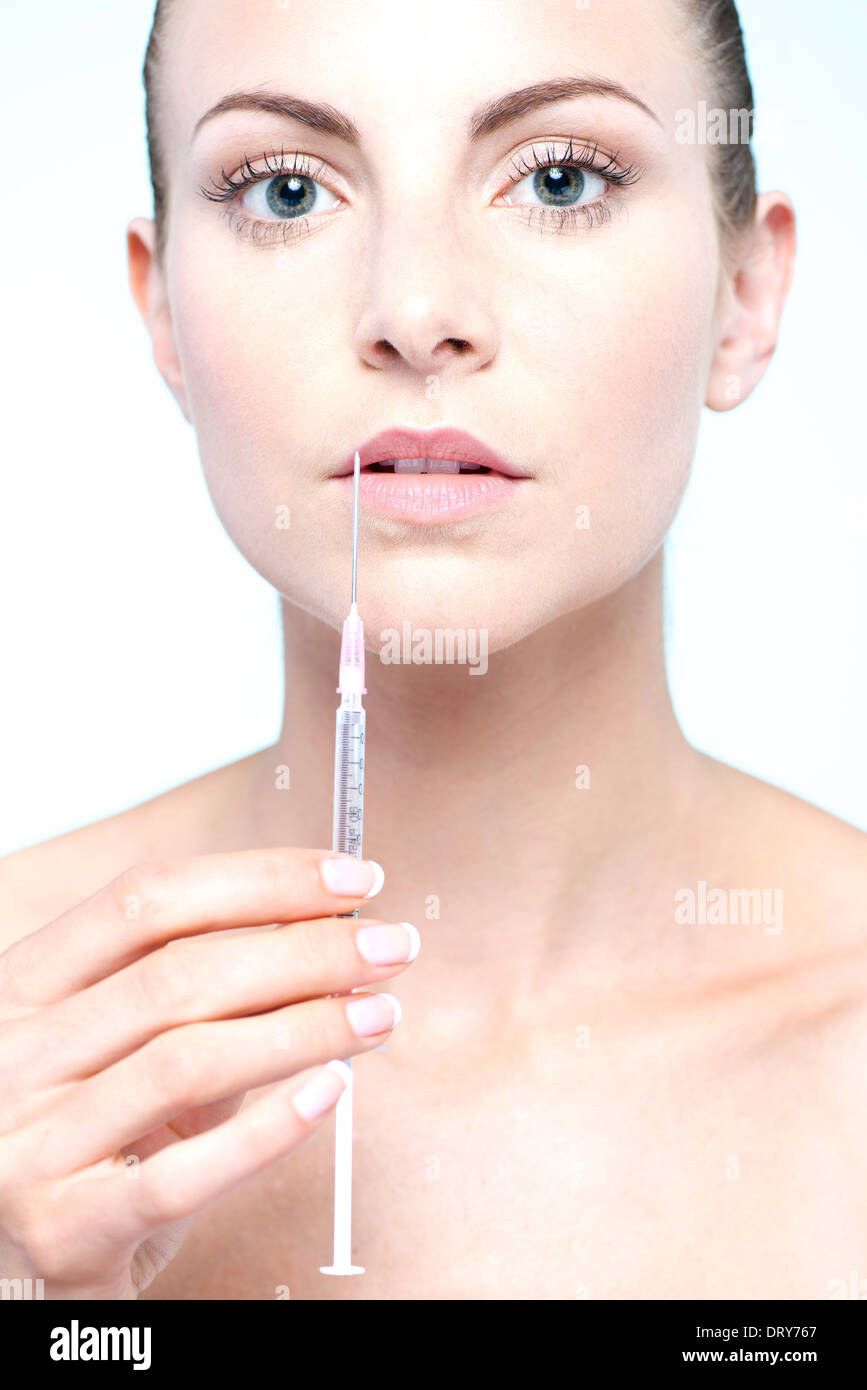 Woman holding up syringe Stock Photo