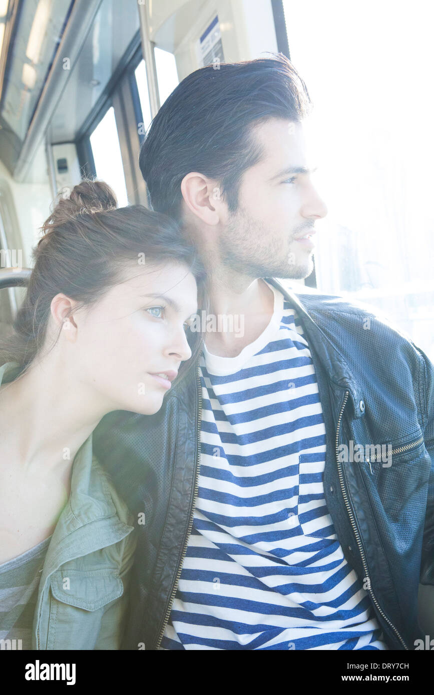 Couple riding train together, looking out window Stock Photo