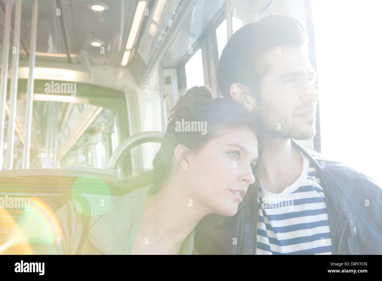 Couple riding train together, looking out window Stock Photo