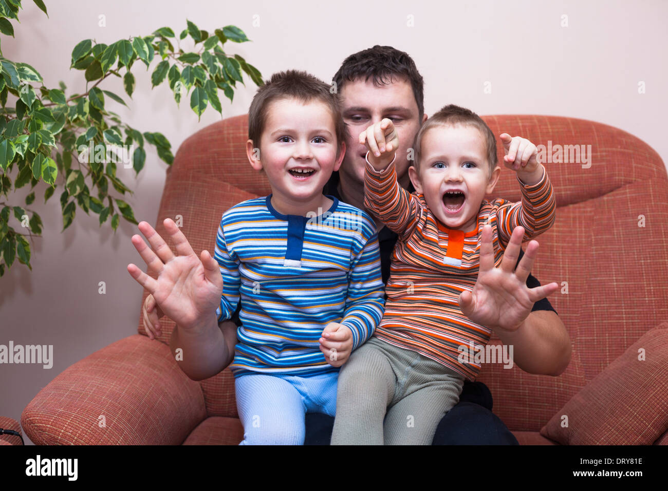 Happy children boys and daddy having fun on sofa at home Stock Photo