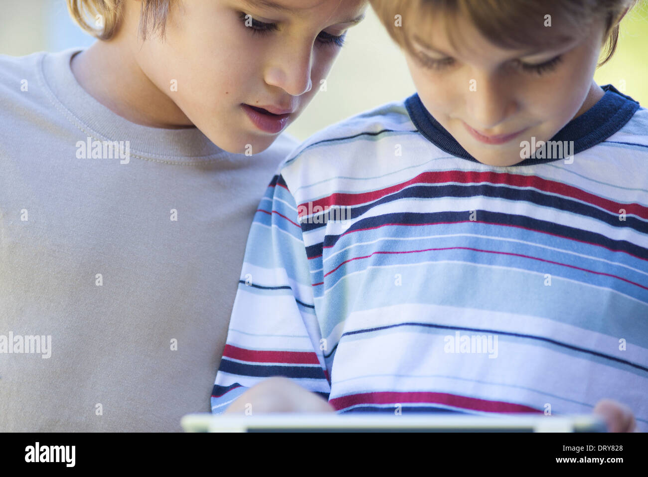 Boys looking down at digital tablet Stock Photo