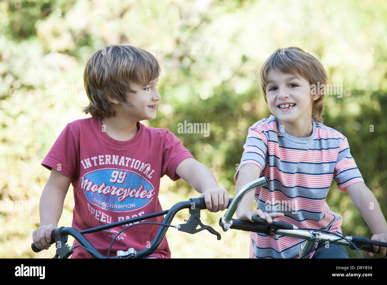 Boys riding bicycles side by side Stock Photo