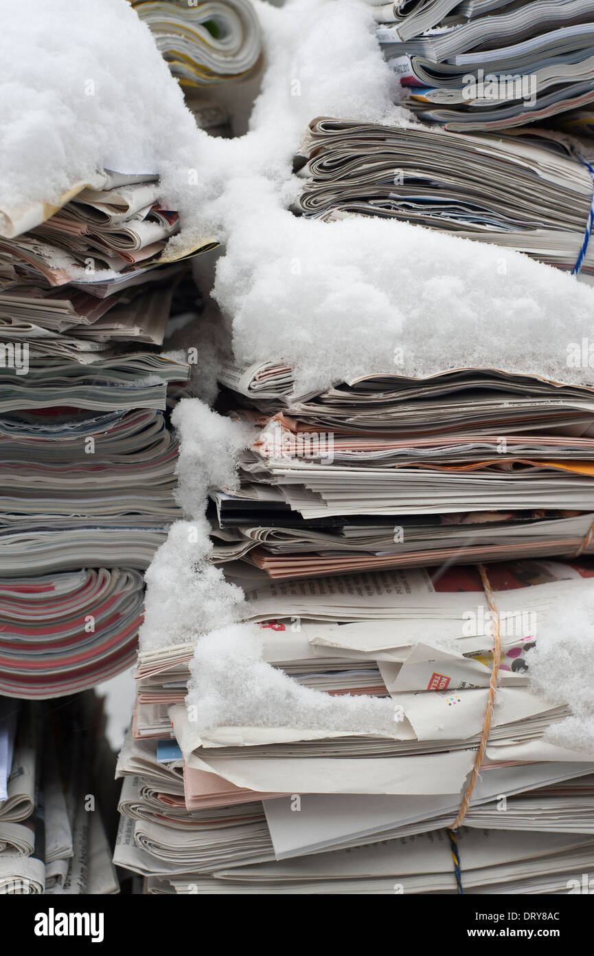 Bundled waste-paper covered with snow is ready to be collected and on a street in a residential area of Zurich, Switzerland. Stock Photo