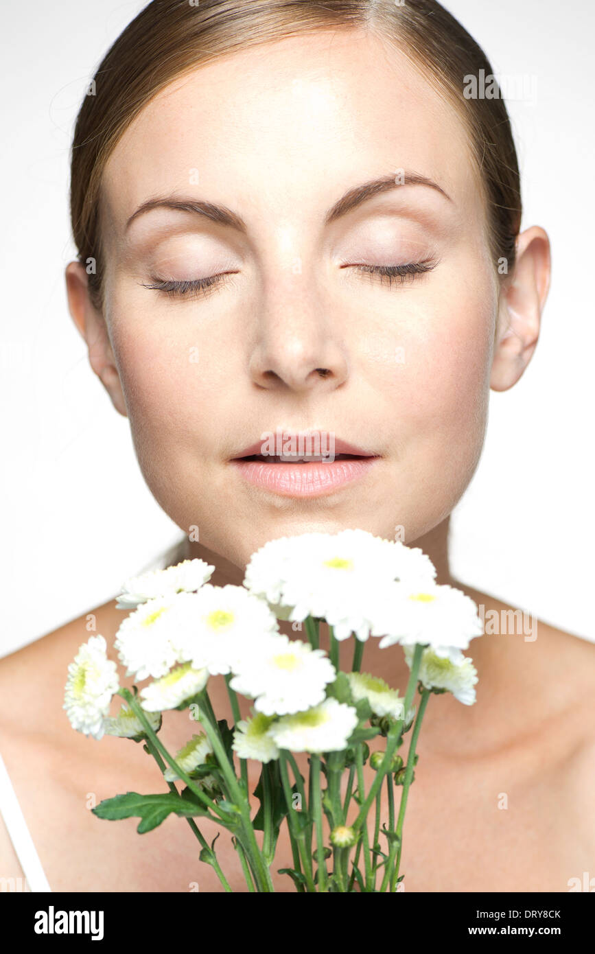 Young woman smelling bouquet of daisies Stock Photo