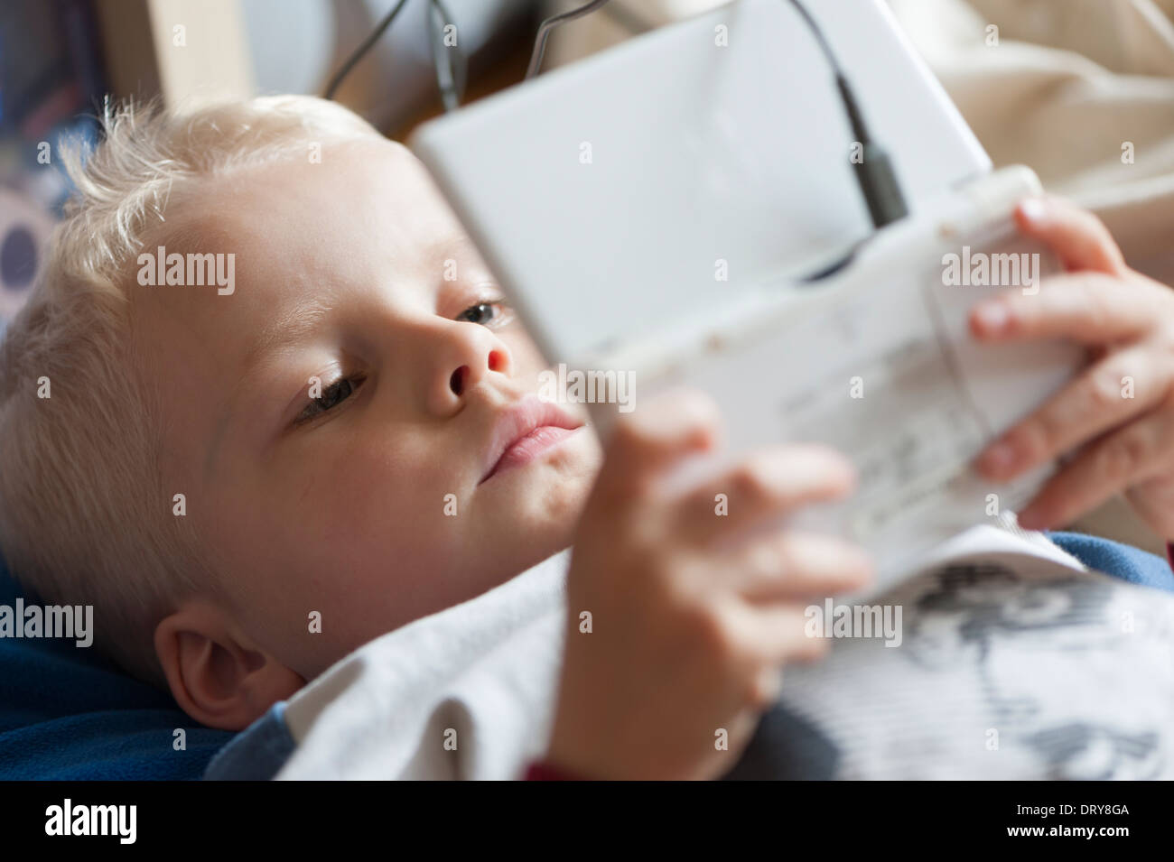 5-year old boy playing with his Nintendo DS game concole Stock Photo