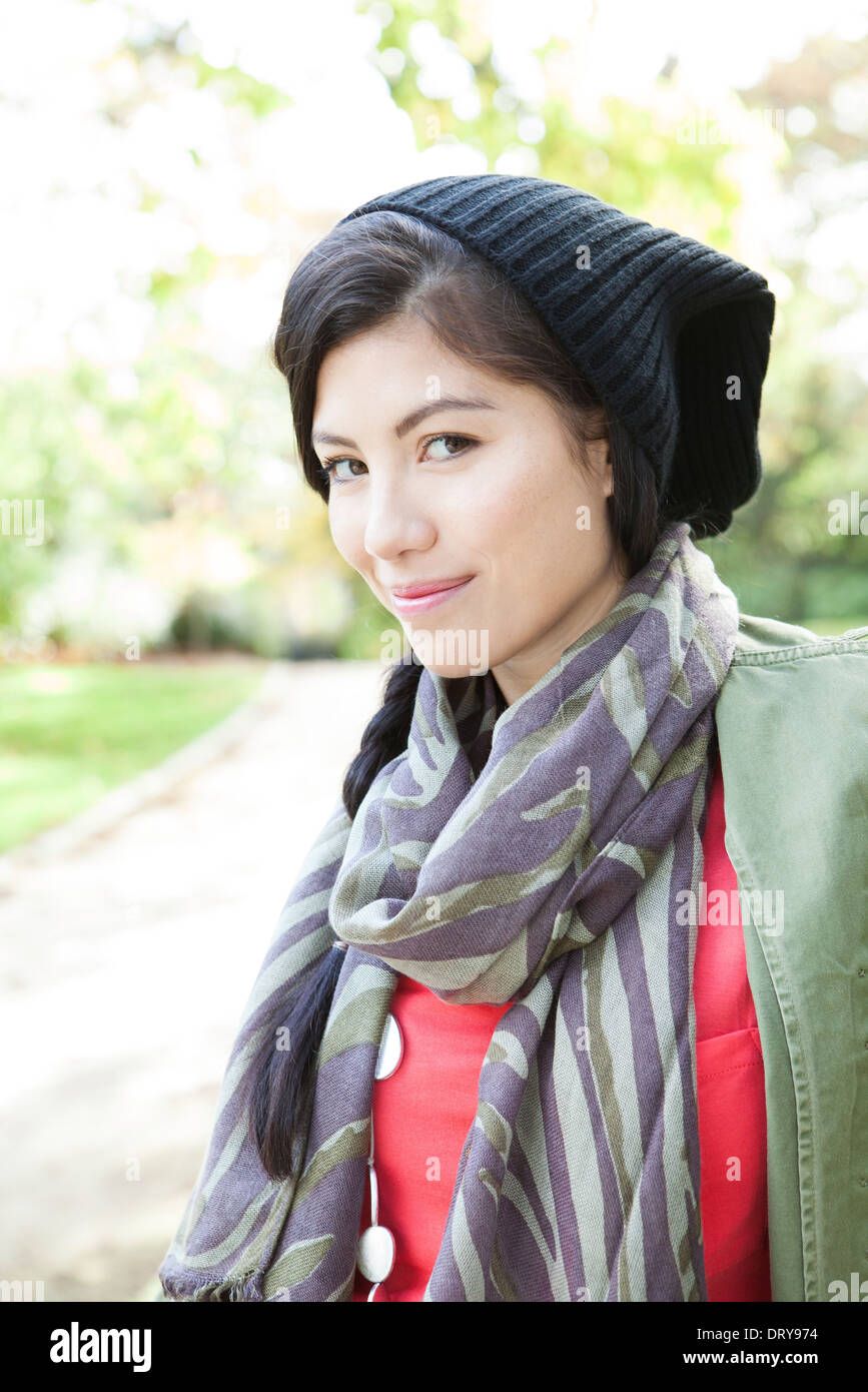 Young woman wearing knit hat and scarf, smiling, portrait Stock Photo