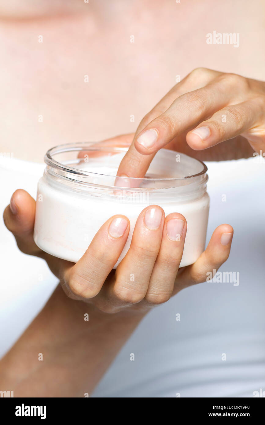 Woman using moisturizing cream Stock Photo