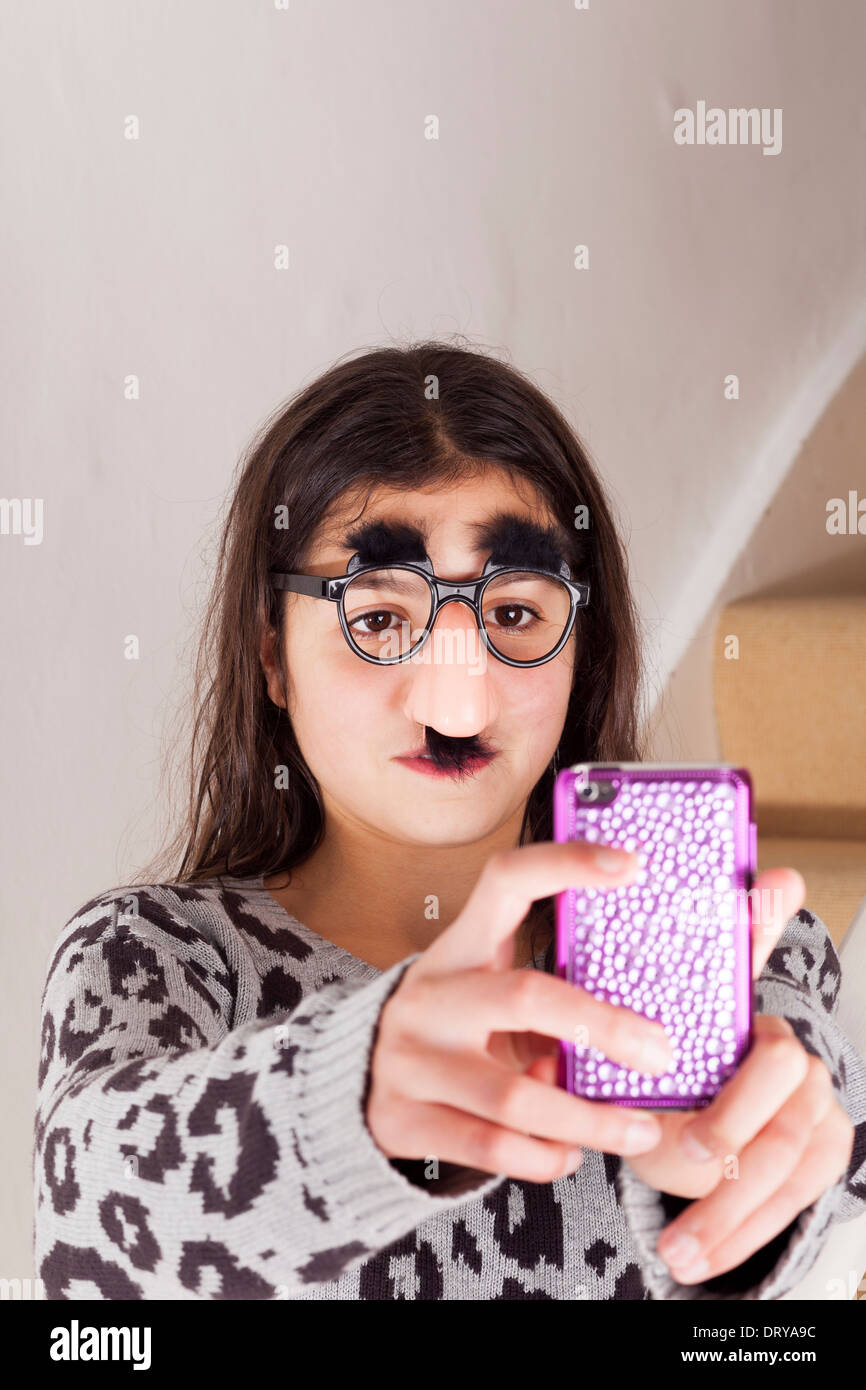 Girl (12-13) in party disguise taking self shot Stock Photo