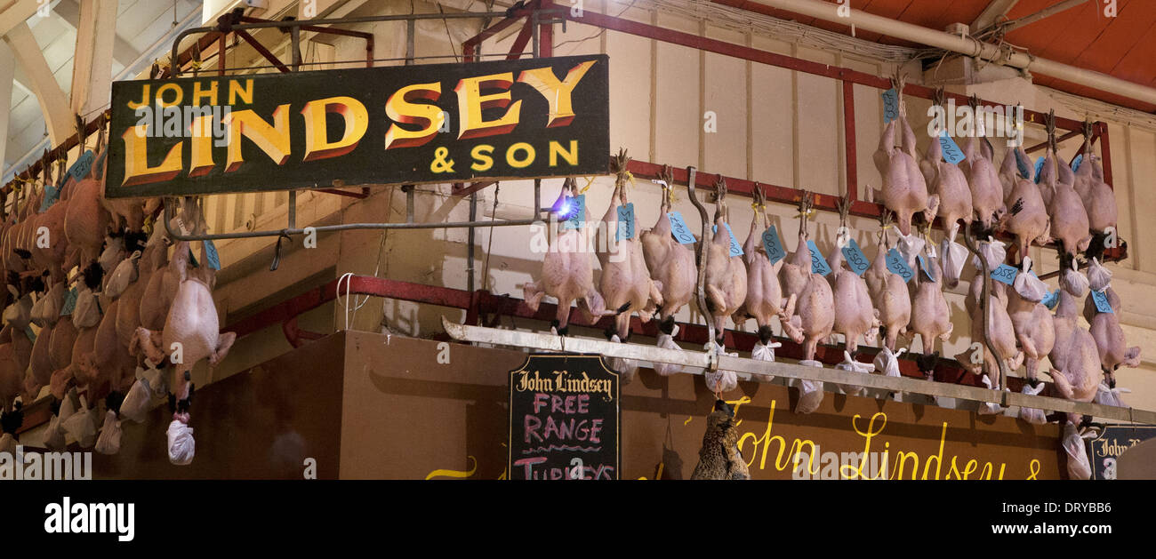 Uncovered Turkeys hanging outside a Butchers shop, old vintage signs hang around the shop exterior. Stock Photo