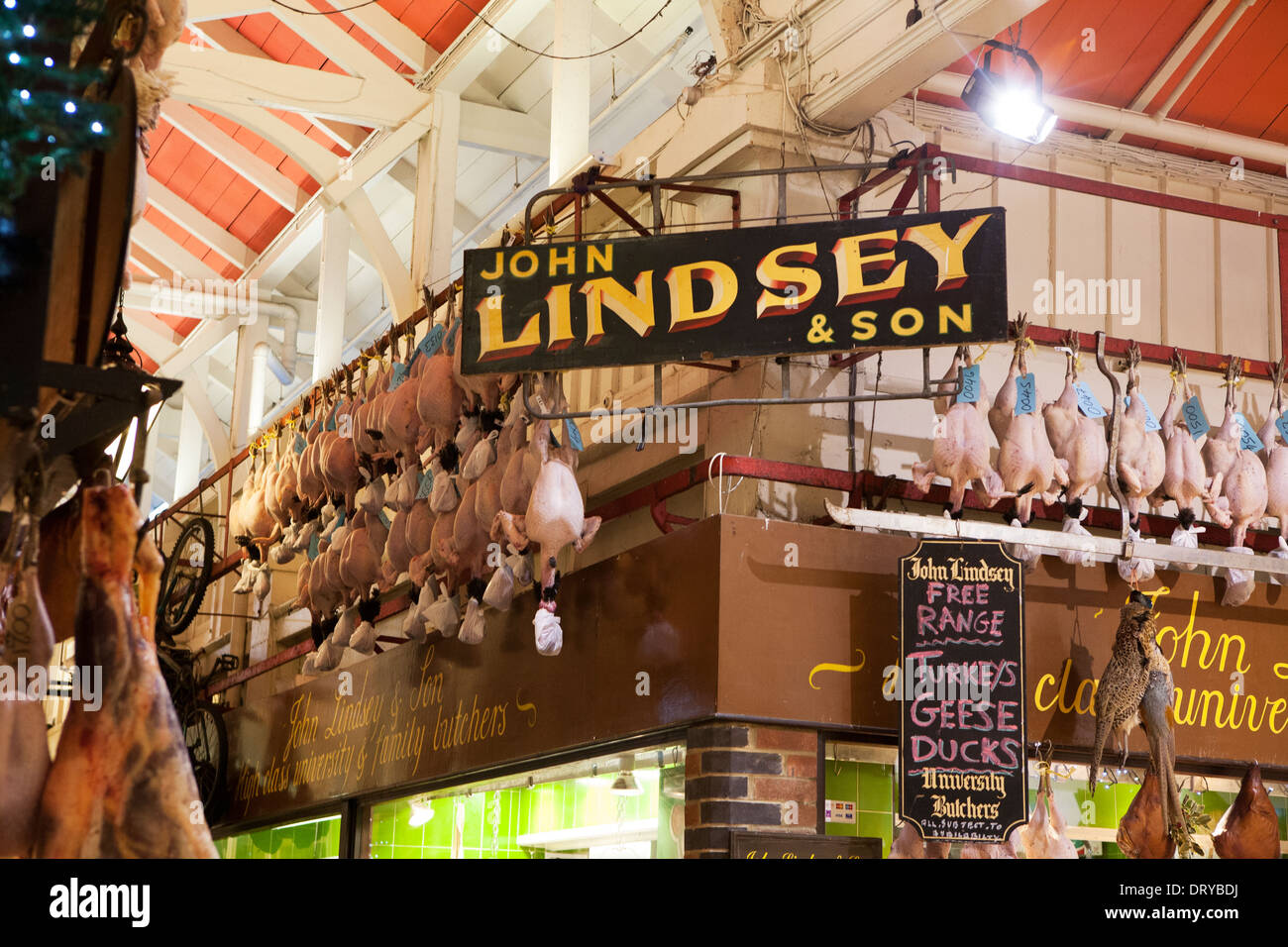 Uncovered Turkeys hanging outside a Butchers shop, old vintage signs hang around the shop exterior. Stock Photo