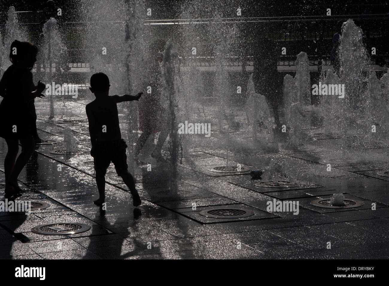 Silhouettes of children playing in water fountains Stock Photo - Alamy