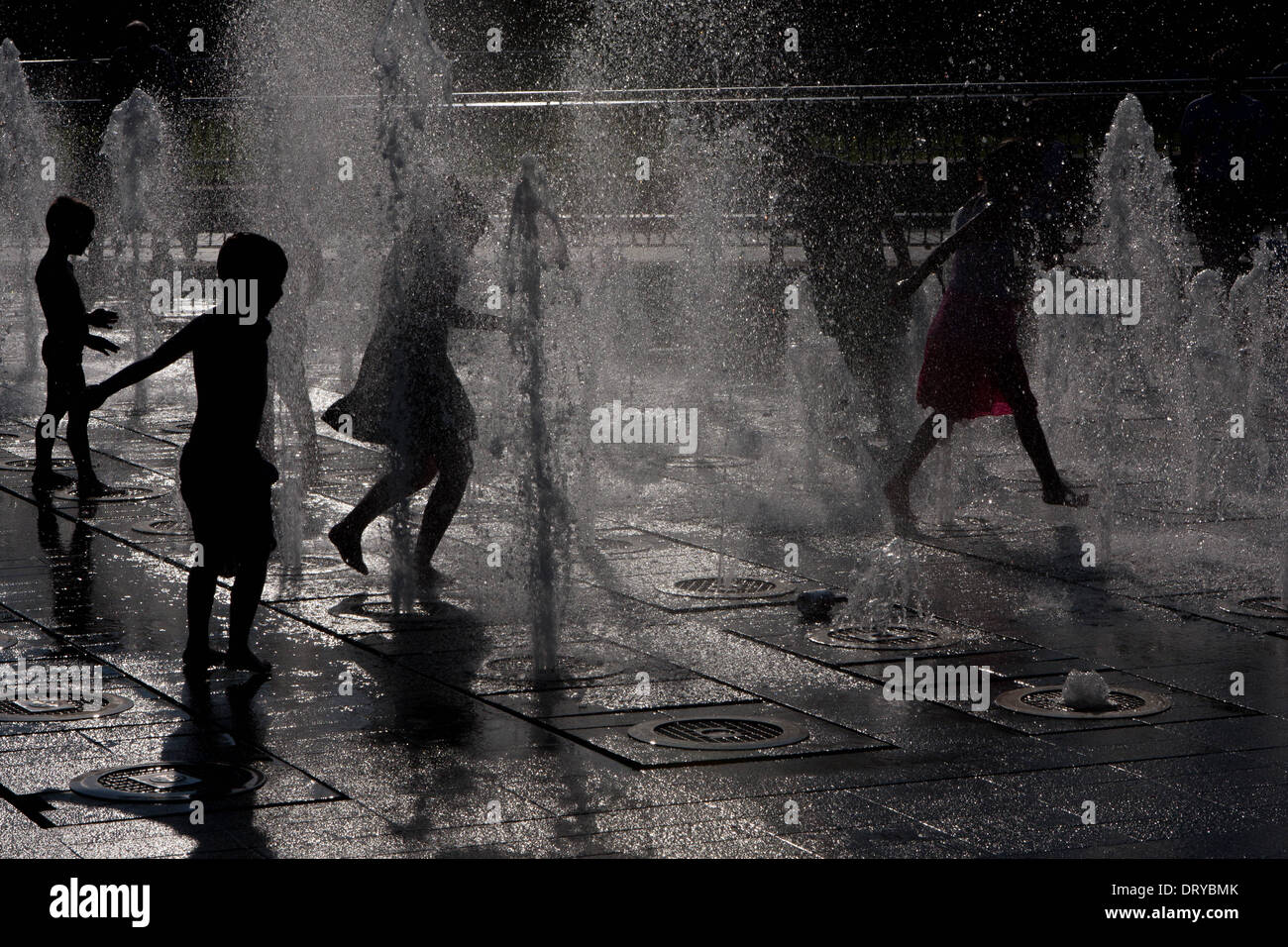 Silhouettes of children playing in water fountains Stock Photo - Alamy