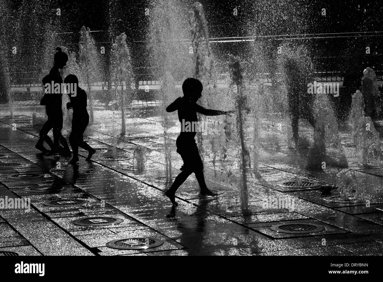 Silhouettes of children playing in water fountains Stock Photo - Alamy
