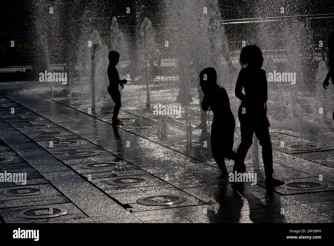 Silhouettes of children playing in water fountains Stock Photo - Alamy